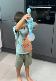 Child wearing a glove using a blue smoke bubble machine indoors