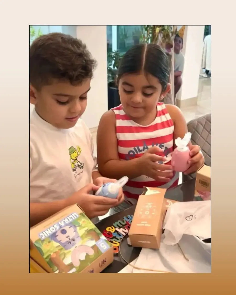 Children opening their toothbrush boxes with adult guidance